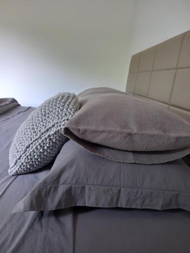 a pile of pillows sitting on top of a bed at Pousada IMcasa 430 in Bento Gonçalves
