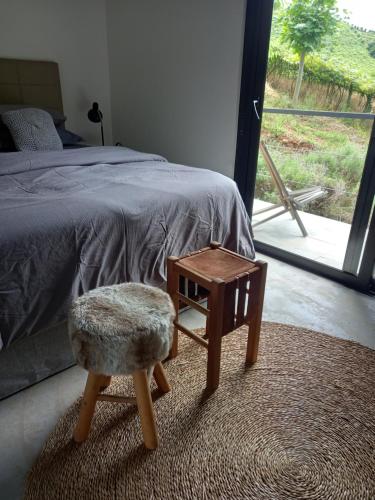 a bedroom with a bed and a stool and a table at Pousada IMcasa 430 in Bento Gonçalves
