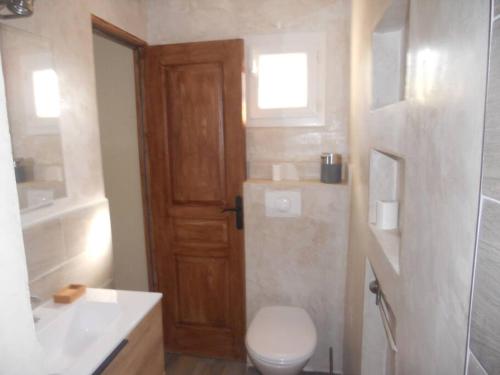ein Bad mit einem WC, einem Waschbecken und einer Tür in der Unterkunft SEJOUR DETENTE BALAGNE ENTRE MER ET MONTAGNE in Urtaca