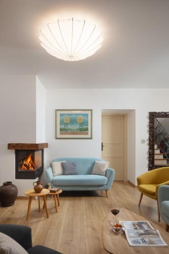 a living room with a blue couch and a fireplace at Mondinica Heritage House - Heated pool in Dobrinj