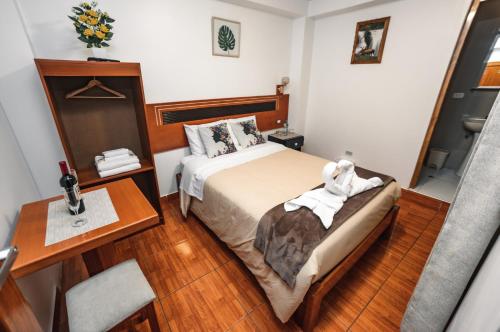 a small room with a bed and a desk and a bed sidx sidx at Escobedo’s Inn Machupicchu in Machu Picchu