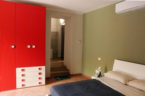 um quarto com armários vermelhos e uma cama em LadimoradiLu' em Piano