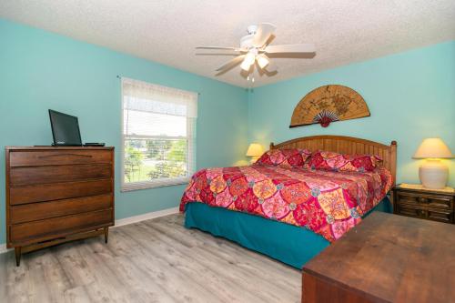 una camera da letto con un letto, una cassettiera e una TV di A Wright Place a Holmes Beach