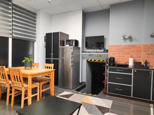 Il comprend une cuisine équipée d'une table, de chaises et d'un réfrigérateur. dans l'établissement Slate Apartament Jedlina - Zdrój, à Jedlina-Zdrój