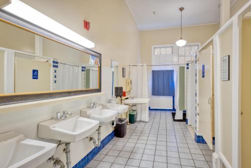 a bathroom with three sinks and two mirrors at HI San Francisco Fisherman's Wharf Hostel in San Francisco