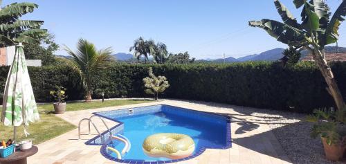 a swimming pool with a float in a yard at Lindissíma casa com piscina Blumenau próx praias in Blumenau