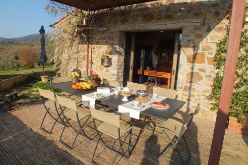 a table and chairs in front of a stone house at Casetta dell`Uliveto in Macchiascandona