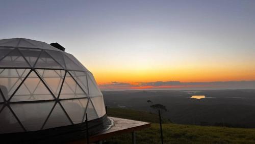 een koepel op een heuvel met de zonsondergang op de achtergrond bij Magical Dome - Top of the World! in Bald Knob
