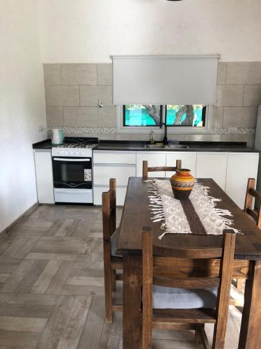 a kitchen with a wooden table with chairs and a stove at 12 Olivos Cabañas in San Rafael