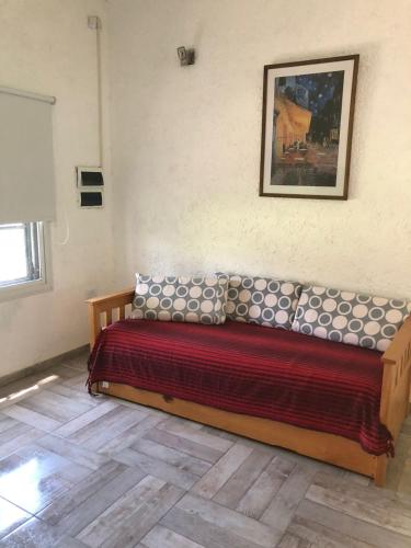 a bed in a room with a picture on the wall at 12 Olivos Cabañas in San Rafael