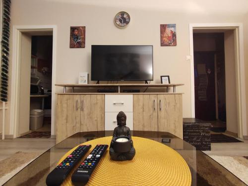 a remote control sitting on a table in front of a tv at Hírös Home in Kecskemét