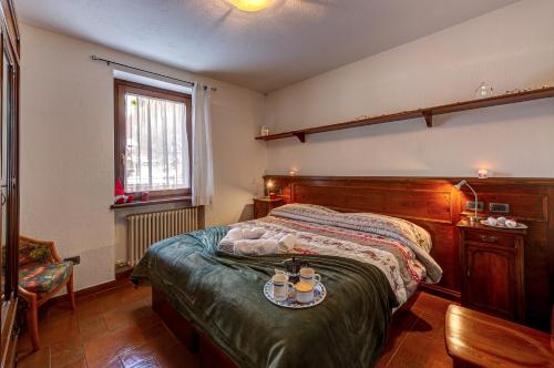 a bedroom with a bed with a tray of food on it at CHALET PONTAL 3 - Relax e vista sulle montagne - COUR 0142 in Courmayeur