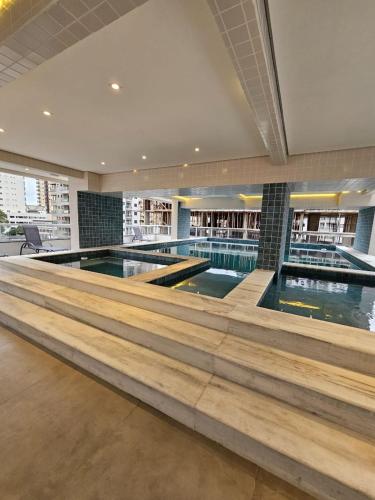 una gran piscina en un edificio con piscina en Residencial affinity 02, en Praia Grande
