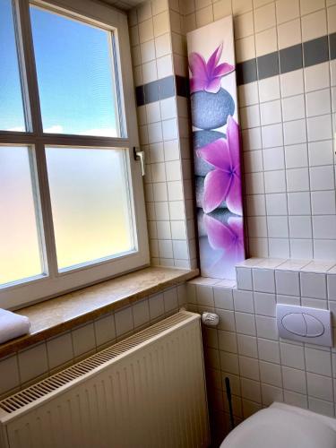 a bathroom with a toilet and a window at Das SinGold Hotel mit Highspeed WLAN und digitalem Schlüssel in Schwabmünchen