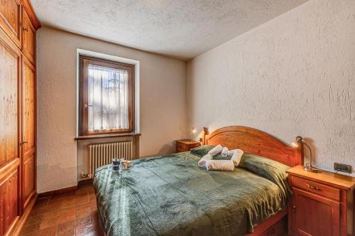 a bedroom with a bed and a window at CHALET PONTAL 3 - Relax e vista sulle montagne - COUR 0142 in Courmayeur