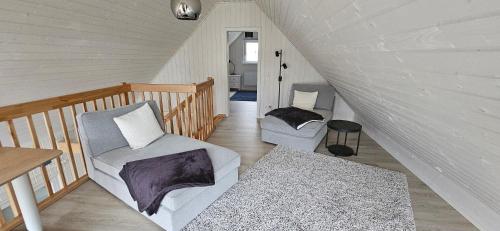 a attic room with two chairs and a table at Schwedenhaus Zerpenschleuse in Wandlitz