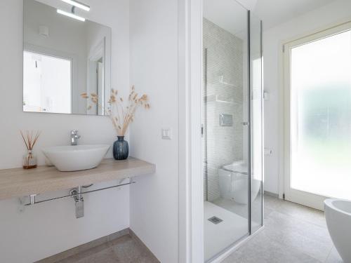 a white bathroom with a sink and a mirror at Villa Serenity in Terra Mala