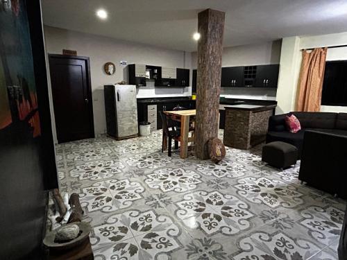 a living room with a table and a kitchen at Hotel Hostal El Castillo Santa in Santa Bárbara