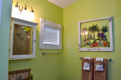 a bathroom with green walls and a window and towels at Lakeside Beach House in Holmes Beach