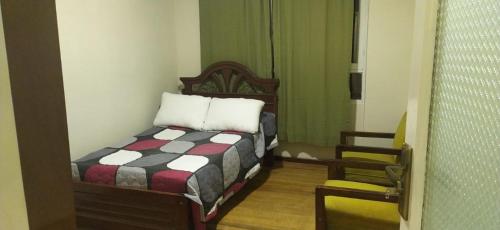1 dormitorio pequeño con 1 cama y 1 silla en Casa Zapata en Cochabamba