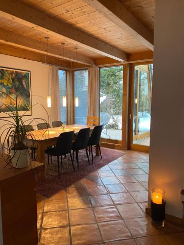 a dining room with a table and chairs and glass doors at Ferienhaus in Westendorf in Westendorf