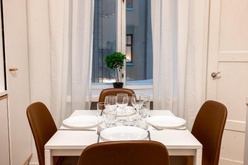 Una mesa blanca con gafas y un jarrón. en 2ndhomes Central & Cozy 1 BR Apartment in Kaisaniemi en Helsinki
