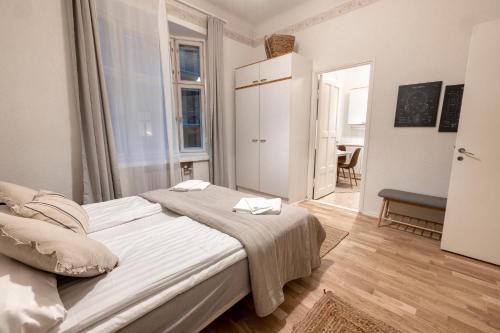 Dormitorio blanco con cama y mesa en 2ndhomes Central & Cozy 1 BR Apartment in Kaisaniemi en Helsinki