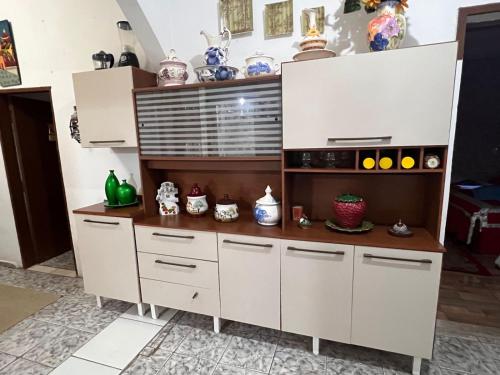 uma cozinha com armários brancos e cerâmicas em A CASA DE IRENE I em Aparecida