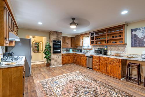 una grande cucina con armadi in legno e un tappeto di Cozy Natchez Home - Close to River & Nature a Natchez