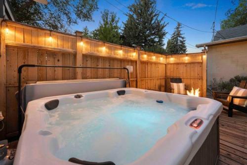 a hot tub in a backyard with lights on a fence at Stylish 1920s Downtown Flagstaff unit with HotTub in Flagstaff