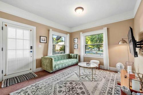 a living room with a green couch and a table at Stylish 1920s Downtown Flagstaff unit with HotTub in Flagstaff