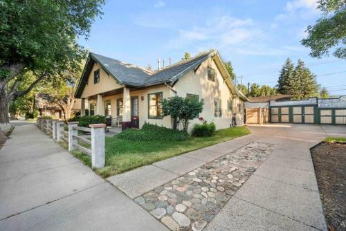 a white house with a fence in front of it at Stylish 1920s Downtown Flagstaff unit with HotTub in Flagstaff