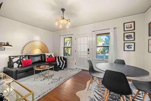 a living room with a black couch and a table at Stylish heart of Downtown Flagstaff Unit with HotTub in Flagstaff