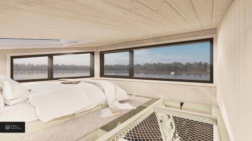 uma cama no centro de um quarto com janelas em MiniBora Le lichen - Cantons-de-l'Est em Bury