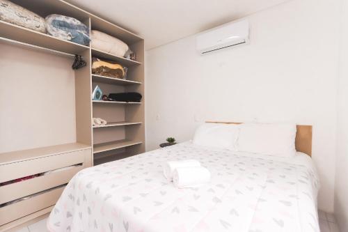 1 dormitorio con cama blanca y armario en Apartamento Completo e Confortável em Bento 02, en Bento Gonçalves