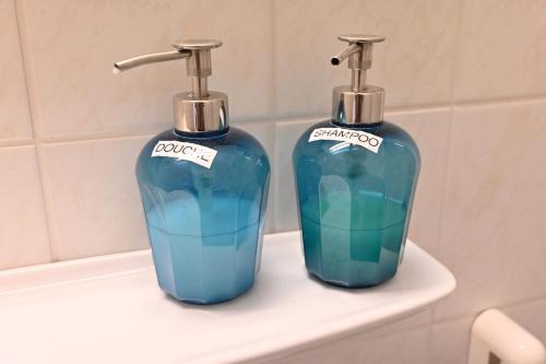- deux bouteilles de savon assises sur un lavabo dans la salle de bains dans l'établissement Vakantie apppartement DE HAAN Park Zeepolder, au Coq