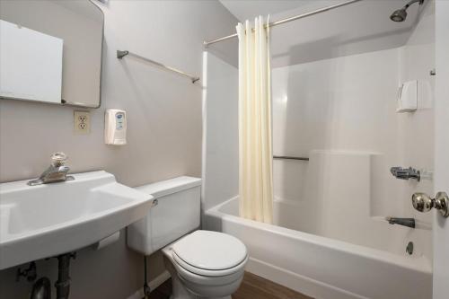 a white bathroom with a toilet and a sink at Beach Bum West-O Cabins in Ocean City