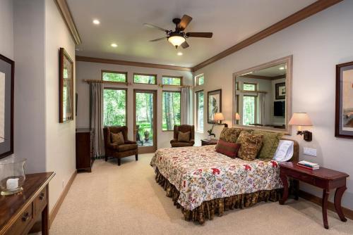 ein großes Schlafzimmer mit einem Bett und einem Deckenventilator in der Unterkunft Riverfront Rainbow Bend Estate with Hot Tub in Ketchum