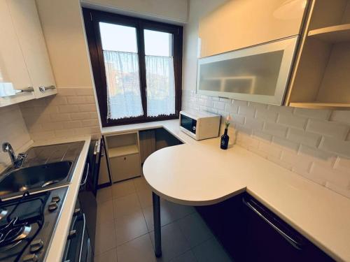 una pequeña cocina con mesa y microondas en Bilocale alle porte di Milano - Magnolia Apartment, en Sedriano
