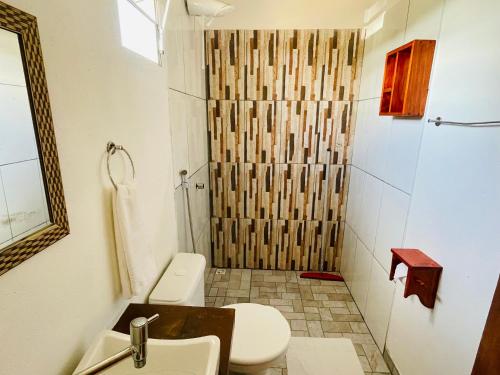 Un baño con ducha, inodoro y lavabo. en Pousada Aquarela, en Caraíva