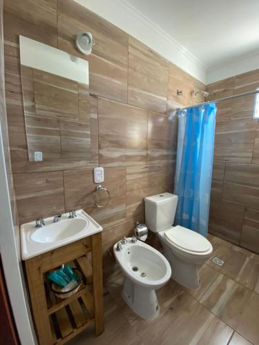 a bathroom with a toilet and a sink and a shower at Departamento los hermanos in Concepción del Uruguay