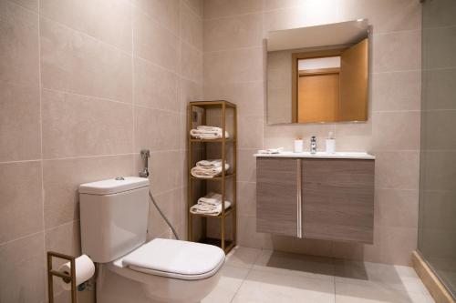 een badkamer met een toilet, een wastafel en een spiegel bij Appartement luxueux Prestigia in Rabat