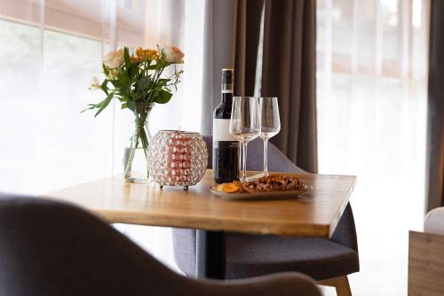a table with a bottle of wine and a vase of flowers at Albchalet in Rosenfeld