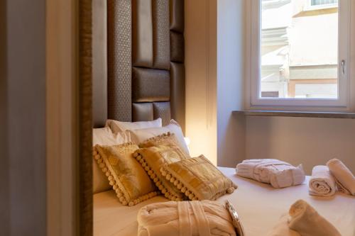 1 cama con almohadas en el espejo en Fontana di Trevi Roma Luxury Suite, en Roma