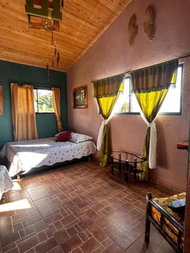 um quarto com uma cama e duas janelas em El castillo santa em Santa Bárbara