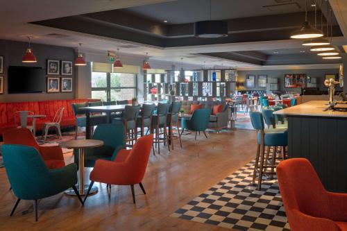 a restaurant with chairs and tables and a bar at DoubleTree by Hilton Edinburgh Airport in Ingliston