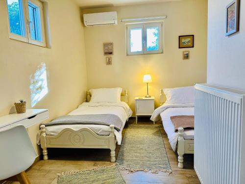 two beds in a room with two windows at Luxury Villa at Pelion- Ruby in Zagora