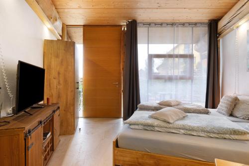 a bedroom with a bed and a tv and a window at Albchalet in Rosenfeld