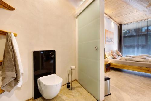 a bathroom with a toilet and a bed in a room at Albchalet in Rosenfeld