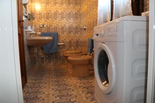 ノヴェンタ・ディ・ピアーヴェにあるAppartamenti via Calnovaのバスルーム(トイレ、洗濯機、乾燥機付)
